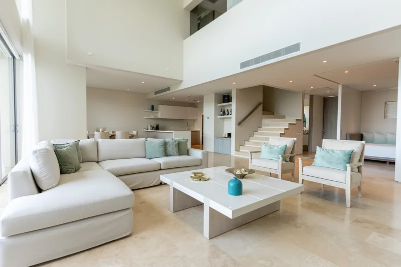 Sala de estar con sofá en L y escalera interior.
